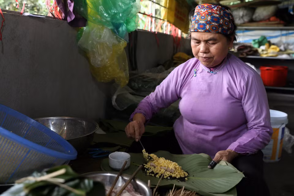 Đồng bào dân tộc người Dáy (Lào Cai) gói bánh chưng đen chuẩn bị đón Tết. (Ảnh: Quốc Khánh/TTXVN)