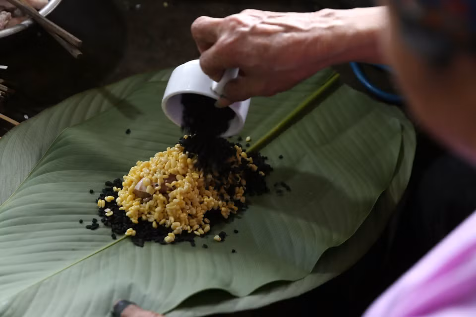 Đồng bào dân tộc người Dáy (Lào Cai) gói bánh chưng đen chuẩn bị đón Tết. (Ảnh: Quốc Khánh/TTXVN)