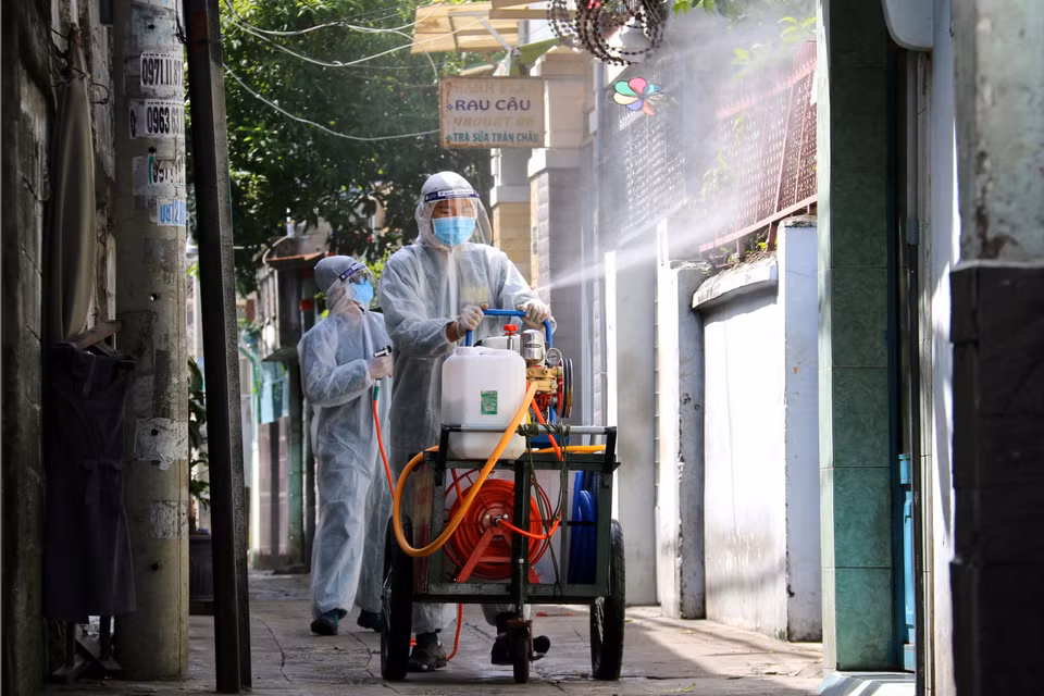 Lực lượng chức năng phường 11, quận 3 tăng cường phụn xịt khử khuẩn khu vực vùng vàng để chuyển hóa thành vùng xanh. (Ảnh: Thanh Vũ/TTXVN)