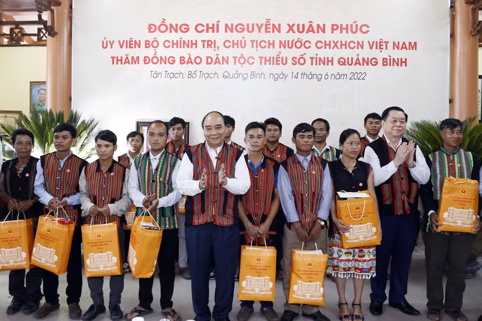 Chủ tịch nước Nguyễn Xuân Phúc tặng quà già làng, trưởng bản tại 2 xã Tân Trạch và Thượng Trạch. (Ảnh: Thống Nhất/TTXVN)