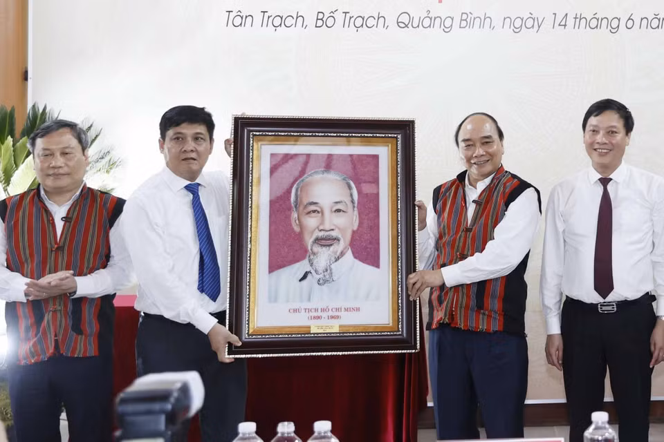 Chủ tịch nước Nguyễn Xuân Phúc tặng phẩm lưu niệm cho đại diện lãnh đạo huyện Bố Trạch, tỉnh Quảng Bình. (Ảnh: Thống Nhất/TTXVN)