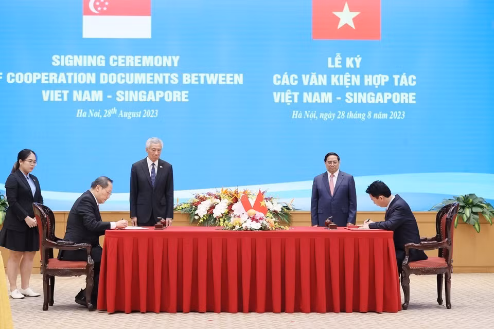 Thủ tướng Phạm Minh Chính và Thủ tướng Singapore Lý Hiển Long chứng kiến ký Ý định thư giữa Bộ Tài nguyên và Môi trường Việt Nam và Bộ Công Thương Singapore về việc tiếp tục thực hiện Bản ghi nhớ hợp tác theo Điều 6 Thỏa thuận Paris. (Ảnh: Dương Giang/TTXVN)