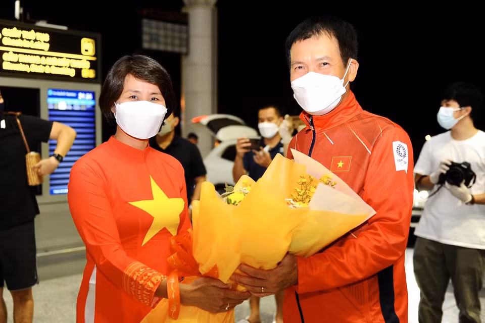Phó Tổng cục trưởng Tổng cục Thể dục Thể thao, bà Lê Thị Hoàng Yến gửi tặng những bó hoa đẹp, chúc đoàn thể thao Việt Nam lên đường vạn sự như ý, nỗ lực thi đấu hết mình, góp phần khích lệ tinh thần nhân dân cả nước cùng chống dịch. (Ảnh: PV/Vietnam+) 