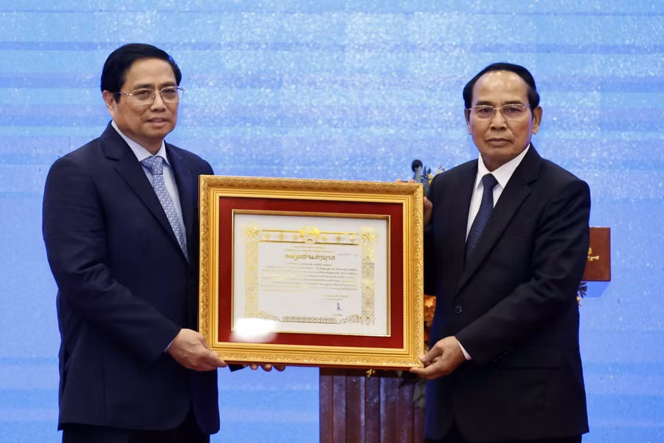 Ông Bounthong Chitmany - Ủy viên Bộ Chính trị, Thường trực Ban Bí thư Trung ương Đảng Nhân dân cách mạng Lào, Phó Chủ tịch nước Cộng hòa dân chủ Nhân dân Lào trao Huân chương Vàng Quốc gia cho ông Phạm Minh Chính - Uỷ viên Bộ Chính trị, Thủ tướng Chính phủ. (Ảnh: Thống Nhất/TTXVN)