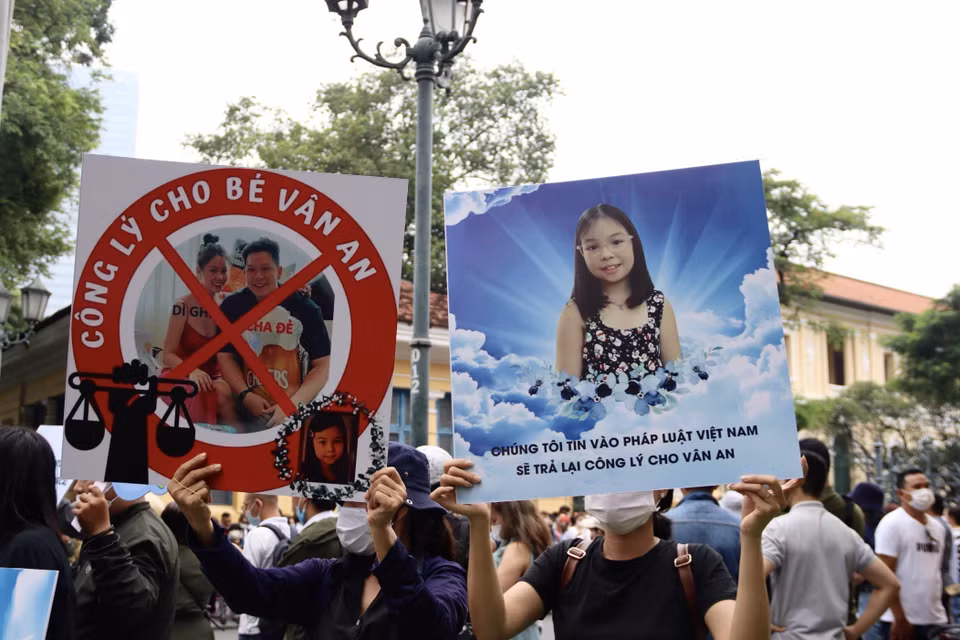Rất đông người dân trong và ngoài Thành phố Hồ Chí Minh căng biểu ngữ ủng hộ người bị hại và theo dõi vụ án bên ngoài phiên tòa. (Ảnh: Thanh Vũ/TTXVN)