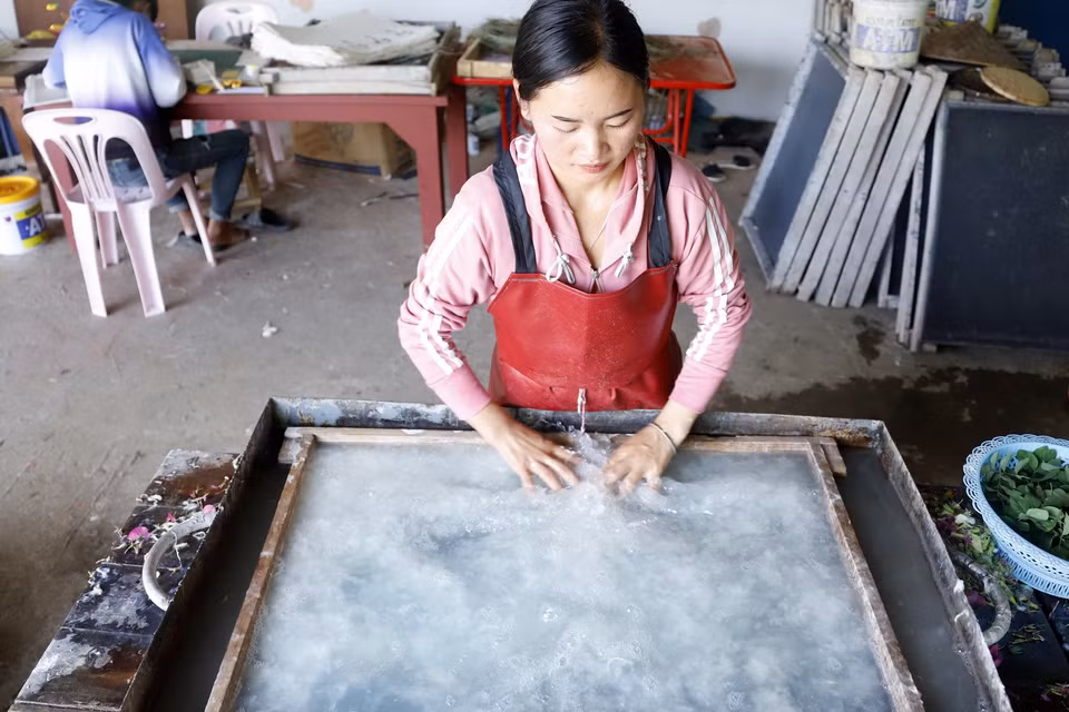 Công đoạn dàn bột giấy trên khuôn. (Ảnh: Phạm Kiên/TTXVN)