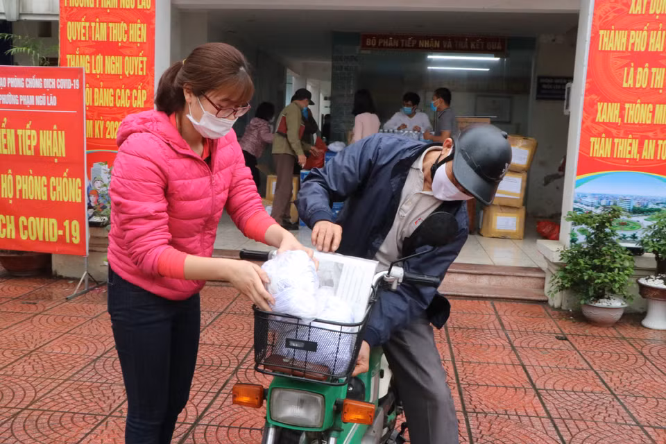 Các trưởng khu dân cư của phường Phạm Ngũ Lão, thành phố Hải Dương nhận vật phẩm do TTXVN và Tỉnh đoàn Hải Dương ủng hộ. (Ảnh: Mạnh Minh/TTXVN)