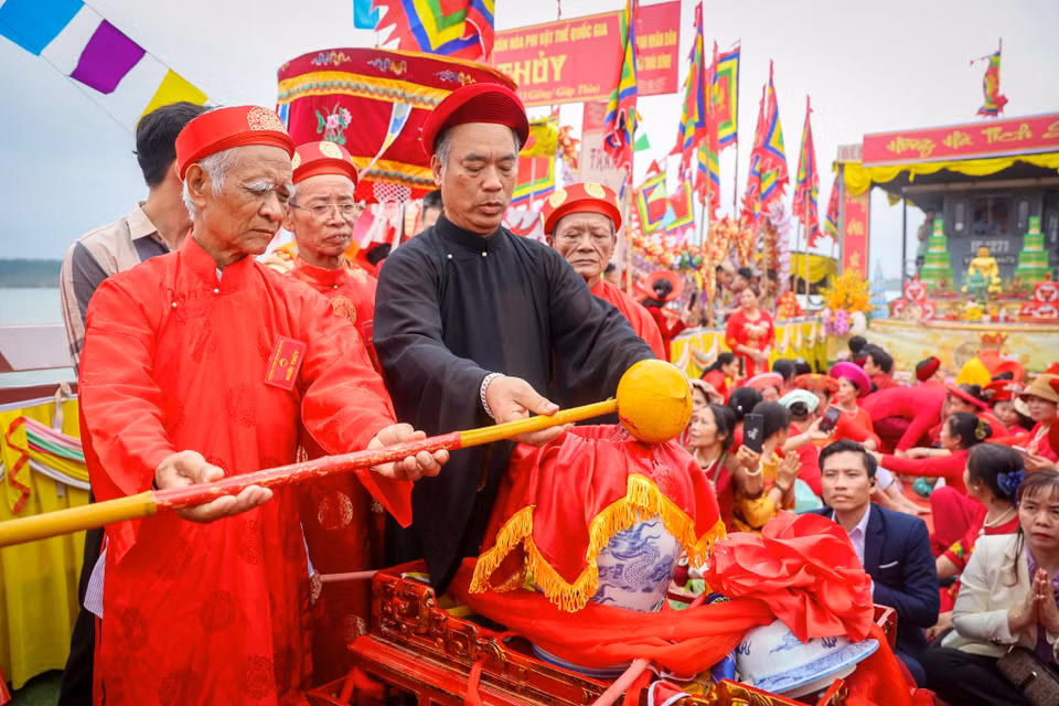 Đến ngã ba Tuần Vường, từng gàu nước được các cụ cao niên và các vị chư tăng trút vào chum nhỏ. (Ảnh: Hoài Nam/Vietnam+)