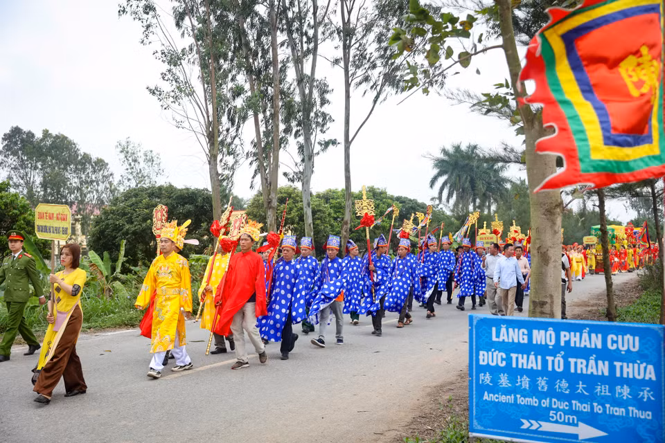 Đoàn rước đi đến đâu đều có đoàn bát âm, cờ trống theo đến đó. Người dân tham gia lễ hội cùng đi theo thành hàng dài với mong muốn được tận mắt chứng kiến lễ rước linh thiêng cũng như cầu cho một năm mưa thuận gió hòa. (Ảnh: Hoài Nam/Vietnam+)