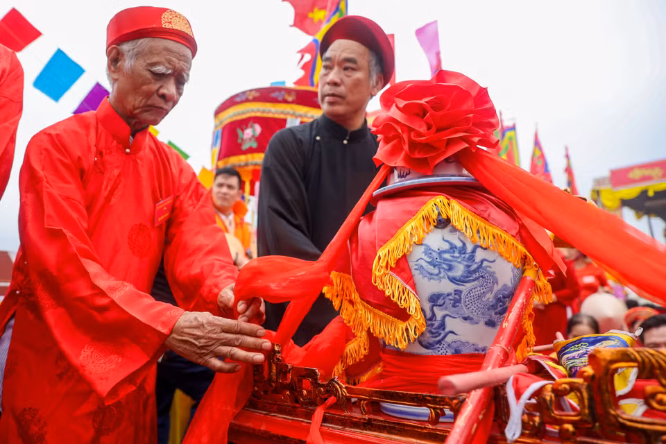 Chum nước được cẩn trọng đặt lên bành, dùng dây lụa đỏ chằng buộc cẩn thận để tránh bị đổ trong khi khiêng kiệu. (Ảnh: Hoài Nam/Vietnam+)