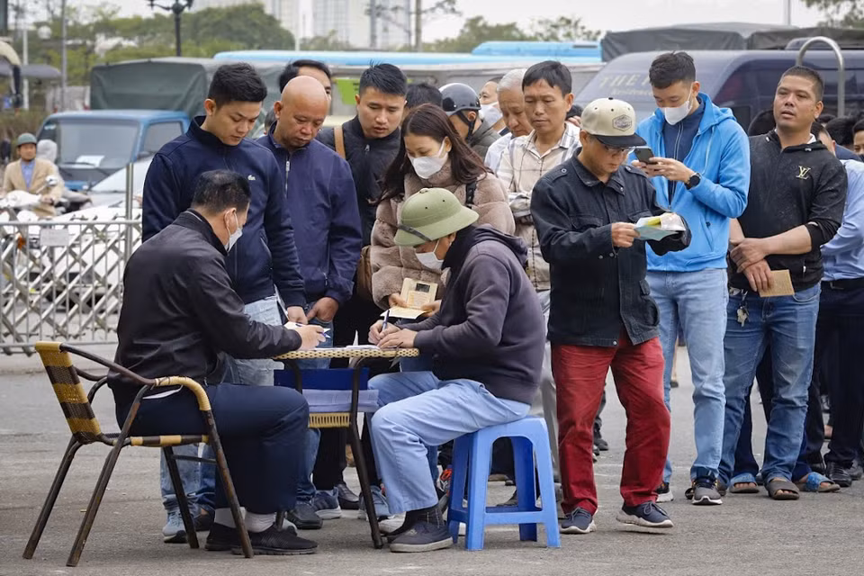 Bên trong khuôn viên trung tâm đăng kiểm, các chủ xe xếp hàng chờ nhận phiếu hẹn thời gian đến đăng kiểm. (Ảnh: Hoài Nam/Vietnam+)