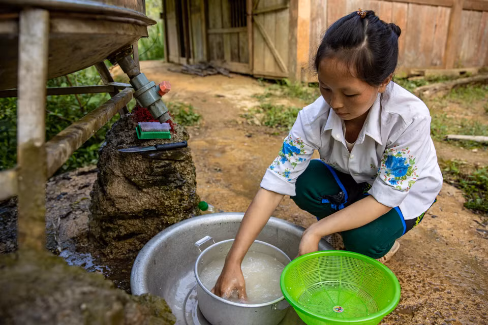 8 giờ, chị Dé bắt đầu công việc của mình, nấu phần cơm trưa có thịt và canh rau. “Ngày trước, các con phải mang theo bữa cơm trưa đạm bạc, thông thường chỉ có cơm trắng, mèn mén hoặc đôi khi thêm một chút rau,” chị Dé bùi ngùi kể lại. (Ảnh: PV/Vietnam+)