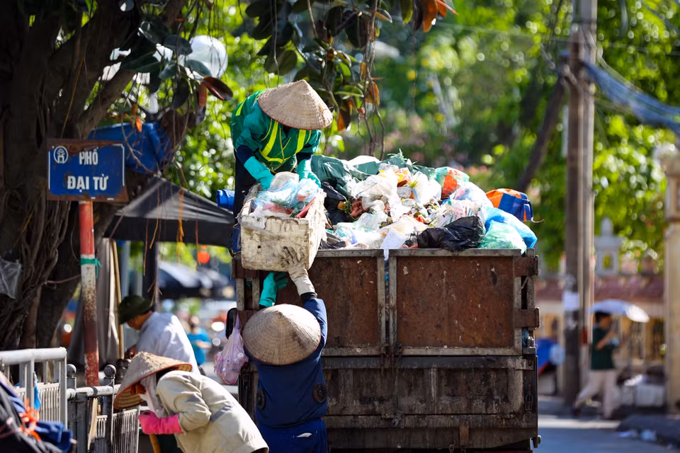 Công nhân vệ sinh môi trường dọn dẹp rác tại khu vực chợ Đại Từ dưới cái nắng như đổ lửa. (Ảnh: Tuấn Hùng/Vietnam+)