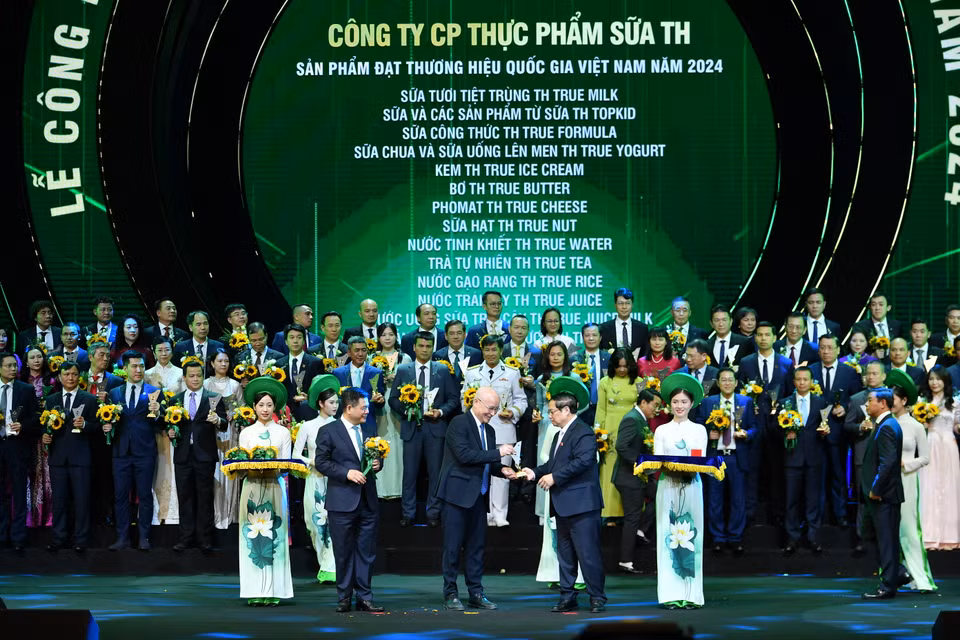 Thủ tướng Chính phủ Phạm Minh Chính và Bộ trưởng Công thương Nguyễn Hồng Diên trao biểu trưng và hoa cho đại diện các doanh nghiệp có sản phẩm đạt Thương hiệu Quốc gia Việt Nam năm 2024. (Ảnh: Hoài Nam/Vietnam+)