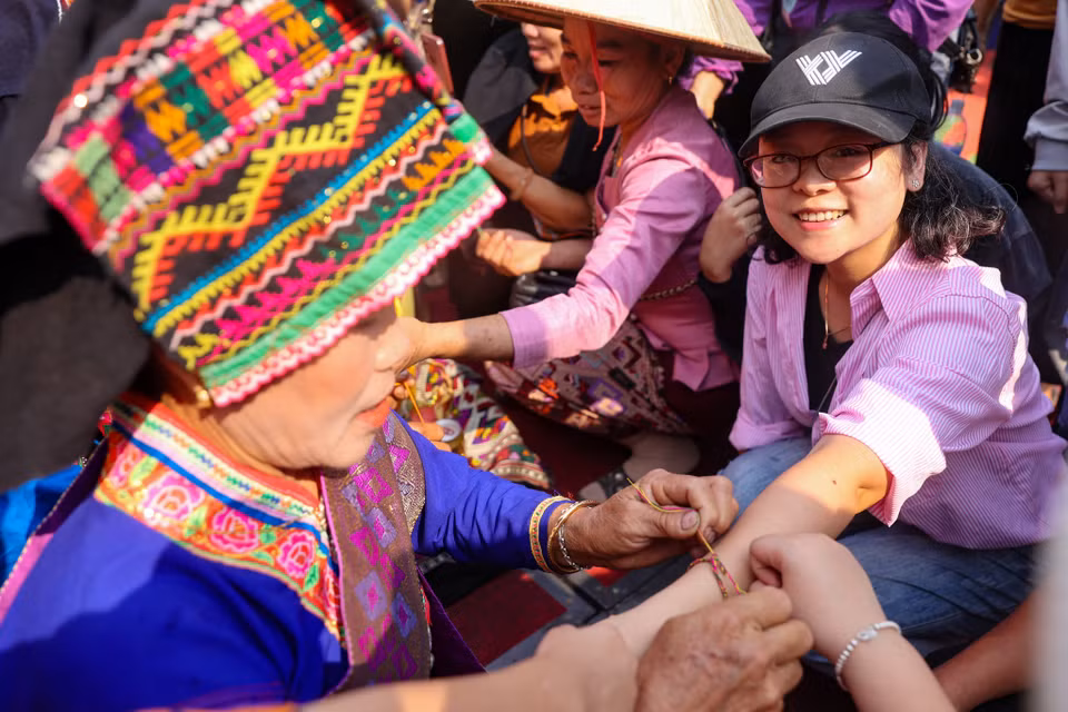 Trong lễ hội này, ai càng được buộc nhiều chỉ ở cổ tay thì càng may mắn. Để thể hiện lòng mến khách của người dân địa phương, những chiếc vòng may mắn thường dành tặng riêng cho khách đến thăm bản. (Ảnh: Hoài Nam/Vietnam+)