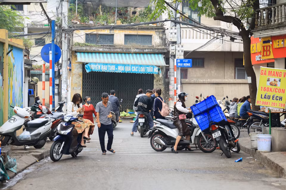 Con phố Mai Động vốn đã chật hẹp lại càng ‘khó thở’ hơn khi vẫn còn hàng quán lấn chiếm, các phương tiện đỗ dài trên đường. (Ảnh: Hoài Nam/Vietnam+)