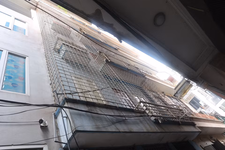 Nằm trong ngõ 161 Định Công Thượng chỉ vừa hai xe máy tránh nhau, phía ban công tòa nhà này cũng bịt kín trong lồng sắt. (Ảnh: Hoài Nam/Vietnam+)