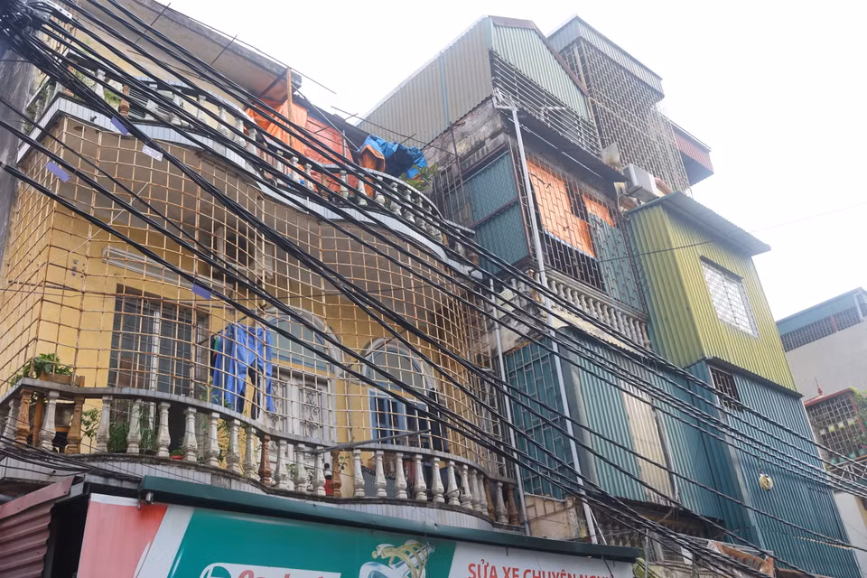 Nằm trên con phố Định Công Thượng, nhiều nhà san sát nhau với 'chuồng cọp' kín mít cùng hệ thống dây điện chằng chịt. (Ảnh: Hoài Nam/Vietnam+)
