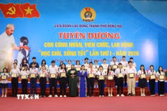 Lãnh đạo Liên đoàn Lao động thành phố Đồng Nai trao thưởng cho con công nhân học giỏi, sống tốt. (Ảnh: Lê Xuân/TTXVN)