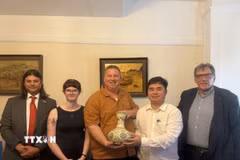 Phó giáo sư, tiến sỹ Phạm Minh Tuấn, Phó Tổng biên tập Tạp chí Cộng sản tặng quà lưu niệm lãnh đạo Đảng Cộng sản Anh. (Ảnh: TTXVN phát).