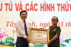 Ông Nguyễn Thanh Hải, Phó Bí thư Tỉnh ủy, Chủ tịch Ủy ban Mặt trận Tổ quốc Việt Nam tỉnh Tây Ninh, trao Danh hiệu Anh hùng lực lượng vũ trang của Chủ tịch nước cho bà Phan Thị Út. (Ảnh: Thanh Bình/TTXVN)