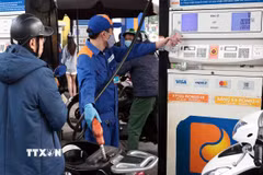 Khách hàng mua bán xăng, dầu tại một điểm kinh doanh xăng dầu của Petrolimex trên địa bàn Hà Nội. (Ảnh: Trần Việt/TTXVN)