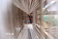 Người phụ nữ Lự ngồi bên khung cửi dệt vải, một nét văn hóa đặc sắc được truyền từ thế hệ này sang thế hệ khác. (Ảnh: Quý Trung/TTXVN)
