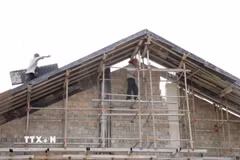 Các công nhân bước vào phần lợp mái tại Trường Phổ thông nội trú liên cấp Tiểu học & Trung học cơ sở xã La Êê, thành phố Đà Nẵng. (Ảnh: Khoa Chương/TTXVN)