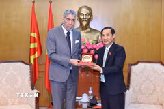 Đồng chí Phó Bí thư chuyên trách Đảng uỷ Dân vận, Mặt trận và các đoàn thể Trung ương Nguyễn Thái Học trao tặng biểu trưng cho đồng chí Miguel Mejia, Tổng Bí thư Đảng Phong trào Cánh tả Thống nhất (MIU), Cộng hòa Dominica. (Ảnh: Minh Đức/TTXVN)
