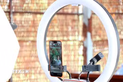 Nhân viên Cơ sở cây giống Nguyễn Triều (xã Chợ Lách, tỉnh Vĩnh Long) livestream bán các sản phẩm cây giống. (Ảnh: Lê Thúy Hằng/TTXVN)