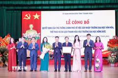 Thứ trưởng Bộ GD & ĐT Lê Quân trao Quyết định của Thủ tướng Chính phủ về sáp nhập Trường Đại học Văn hóa, Thể thao và Du lịch Thanh Hóa vào Trường Đại học Hồng Đức. (Ảnh Khiếu Tư/TTXVN)