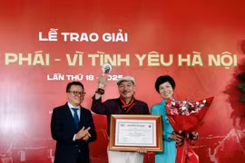 Ông Lê Quốc Minh, Ủy viên Trung ương Đảng, Chủ tịch Hội Nhà báo Việt Nam, Tổng Biên tập Báo Nhân Dân và Tổng Giám đốc Thông tấn xã Việt Nam Vũ Việt Trang trao Giải thưởng Lớn cho nhạc sỹ Trần Tiến. (Ảnh: Huy Thông/TTXVN)