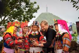 Khách quốc tế cho phụ nữ dân tộc Lô Lô ở Lũng Cú (Hà Giang) xem lại tấm hình selfie. (Ảnh: Trương Thế Cầu)