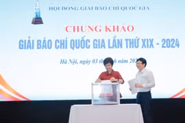Tổng Giám đốc Thông tấn xã Việt Nam - bà Vũ Việt Trang và nhà báo Hồ Quang Lợi, thành viên Hội đồng chung khảo bỏ phiếu chấm các tác phẩm. (Ảnh: Minh Quyết/TTXVN)