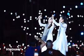 Cẩm Ly và Hòa Minzy thể hiện ca khúc “Người Việt mình thương nhau” trong đó cụm từ "lúa chín cúi đầu" được thay đổi. (Ảnh: PV/Vietnam+)
