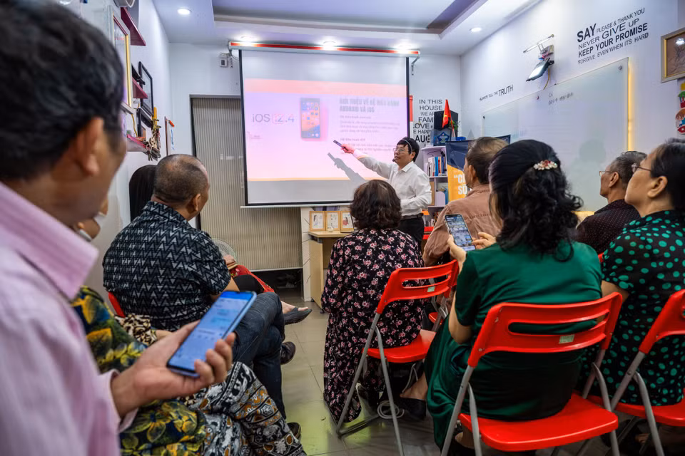 Căn phòng học chỉ rộng vài chục mét vuông nhưng luôn kín chỗ. Mỗi lớp khoảng 15-20 học viên, chia thành 3 lớp học liên tiếp. Người học chỉ cần một chiếc điện thoại thông minh. (Ảnh: Minh Sơn/Vietnam+)