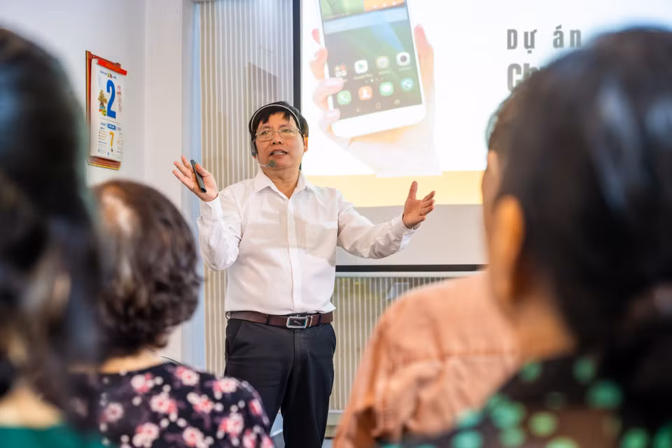 "Tuổi già đến nếu mình không học sẽ chậm từ tư duy đến hành động," ông nói. Chính trải nghiệm tự học công nghệ ở tuổi lục tuần đã trở thành ngọn lửa truyền cảm hứng giúp ông kết nối được với học viên cùng độ tuổi. "Người già sợ dùng công nghệ, sợ bị lừa đảo, sợ ấn nhầm. Nhưng khi tôi học được, tôi dạy lại và chứng minh cho họ thấy rằng: học công nghệ không có tuổi." (Ảnh: Minh Sơn/Vietnam+)