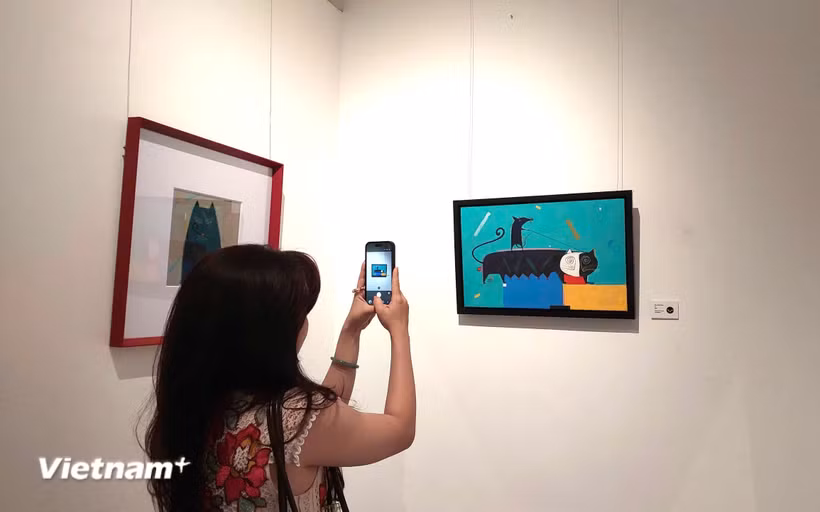 Họa sỹ không hướng tới việc tái hiện con mèo theo lối tả thực, mà anh vẽ mèo với sự giản lược về hình thể, đường nét được biến đổi; dáng mèo trở thành hình khối, đường cong, nhịp điệu và tương quan trên mặt tranh. (Ảnh: Minh Thu/Vietnam+)