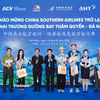 Những du khách đầu tiên từ Thâm Quyến (Trung Quốc) đến Đà Nẵng được chào đón và tặng quà lưu niệm. (Ảnh: PV/Vietnam+)