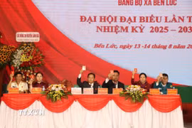 Đoàn Chủ tịch Đại hội Đảng bộ xã Bến Lức biểu quyết thông qua dự thảo Nghị quyết Đại hội. (Ảnh: Thanh Bình/TTXVN)