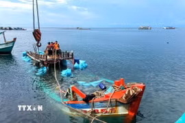 Tàu cá BT 93185 TS bị nạn trên biển được cán bộ, chiến sỹ Đồn Biên phòng Hòn Chuối và ngư dân hỗ trợ lai dắt vào bờ. (Ảnh: Hoàng Tá/TTXVN)