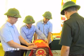 Lãnh đạo xã Vĩnh Bảo cùng lực lượng chức năng tiếp nhận, bảo quản các bộ hài cốt. (Ảnh: Hoàng Ngọc/TTXVN)