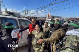 Các thành viên Lữ đoàn Al-Qassam và Al-Quds tiến hành lễ trao trả 4 nữ binh sỹ Israel cho Ủy ban Chữ thập Đỏ Quốc tế (ICRC) tại thành phố Gaza, ngày 25/1/2025. (Ảnh: AA/TTXVN)