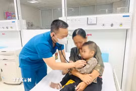 Bác siỹ thăm khám sau khi bệnh nhi được gắp dị vật mắc trong thực quản và sức khỏe dần ổn định. (Ảnh: TTXVN phát)