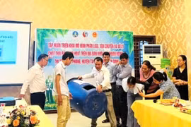 Tiến sỹ Võ Anh Khuê (thứ 3, bên trái sang) hướng dẫn sử dụng thùng ủ rác có thể tích 220 lít cho người dân ở thị trấn Phú Phong, huyện Tây Sơn, tỉnh Bình Định. (Ảnh: Vusta)