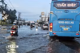 Nhiều đoạn đường trên Quốc lộ 1A qua tỉnh Cà Mau ngập nặng, gây khó khăn cho phương tiện và người tham gia giao thông. (Ảnh: Trung Hiếu/TTXVN)