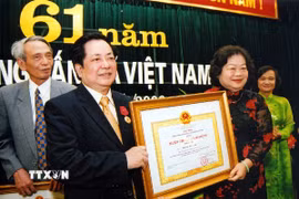 Phó Chủ tịch nước Trương Mỹ Hoa trao Huân chương Lao động hạng Nhì tặng Phó Tổng Giám đốc Thông tấn xã Việt Nam Trương Đức Anh nhân dịp kỷ niệm 61 năm Ngày truyền thống Thông tấn xã Việt Nam, tháng 9/2006.
