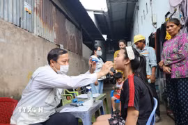 Bác sỹ Trạm Y tế xã Hiệp Phước khám, kiểm tra sức khỏe cho học sinh khu vực ghi nhận ca bệnh não mô cầu. (Ảnh: Đinh Hằng/TTXVN)