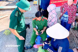 Chiến sỹ Biên phòng Hòn Chuối phối hợp cùng lực lượng Công an trực tiếp hỗ trợ hộ dân thực hiện các đăng ký tài khoản định danh điện tử. (Ảnh: Chanh Đa/Vietnam+)