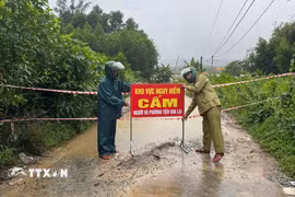 Lực lượng chức năng thành phố Đà Nẵng cắm biển cảnh báo tại những vùng bị ngập lụt do mưa lớn. (Ảnh: TTXVN phát)